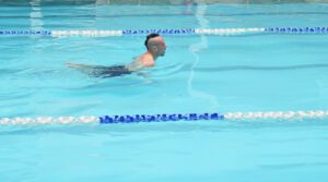 Man swimming in a bright blue swimming pool