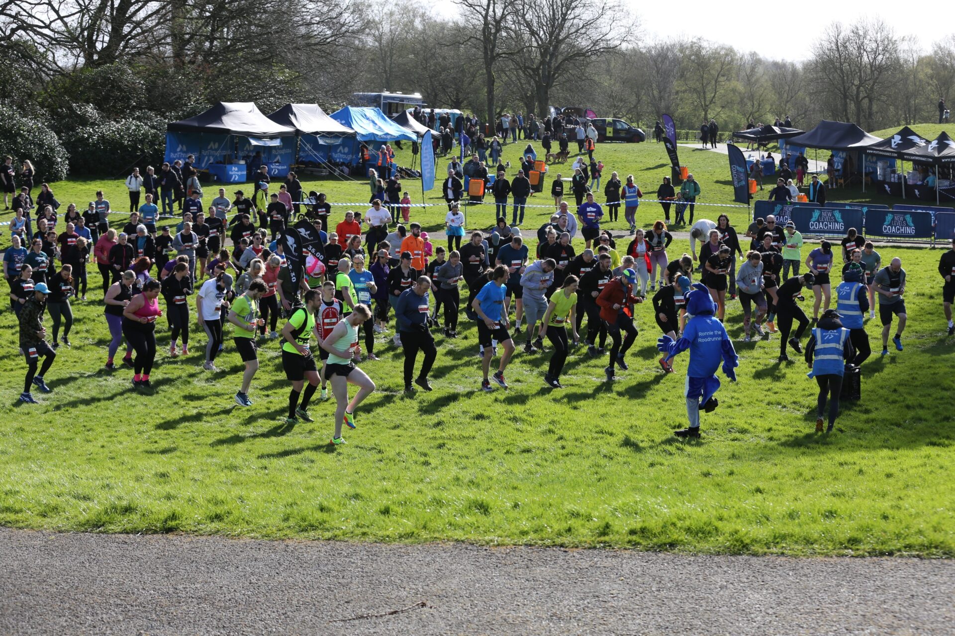 A big group of runners taking part in a warm up before the Heaton Park race begins