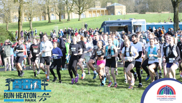 Large group of runners warming up in a park