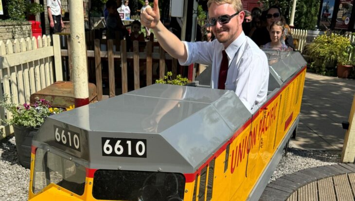 Man riding a miniature yellow railway