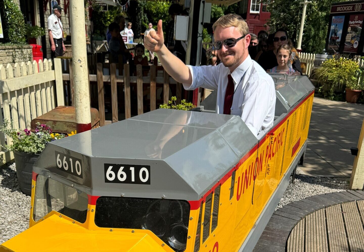 Man riding a miniature yellow railway